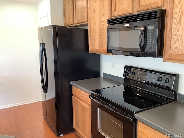 11947 Riverstone Cir Unit 7F, Henderson, CO 80640 - kitchen featuring black appliances, wood finished floors, and baseboards
