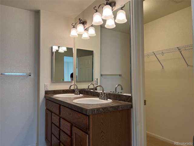 11947 Riverstone Cir Unit 7F, Henderson, CO 80640 - full bath featuring a walk in closet, a chandelier, double vanity, and baseboards