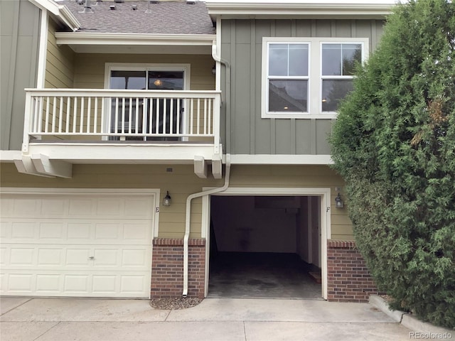 11947 Riverstone Cir Unit 7F, Henderson, CO 80640 - view of front of home featuring a balcony, board and batten siding, a garage, brick siding, and concrete driveway