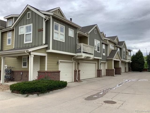 11947 Riverstone Cir Unit 7F, Henderson, CO 80640 - view of front of house with brick siding, board and batten siding, a garage, and a balcony
