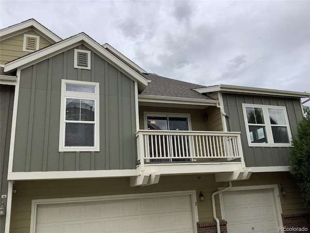 11947 Riverstone Cir Unit 7F, Henderson, CO 80640 - view of front of property with a balcony, board and batten siding, a garage, and roof with shingles