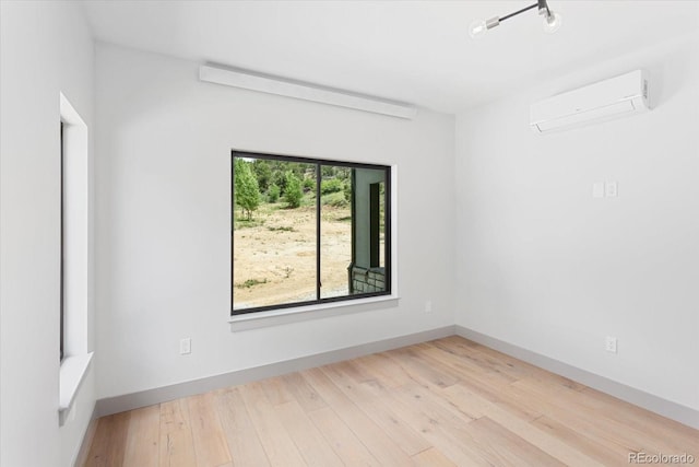 unfurnished room with light wood-type flooring and an AC wall unit