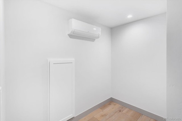 spare room featuring light hardwood / wood-style flooring and an AC wall unit