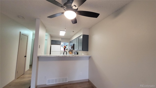 1818 S Quebec Way Unit 5-7, Denver, CO 80231 - kitchen featuring fridge, light wood-style flooring, a textured ceiling, a ceiling fan, and light countertops