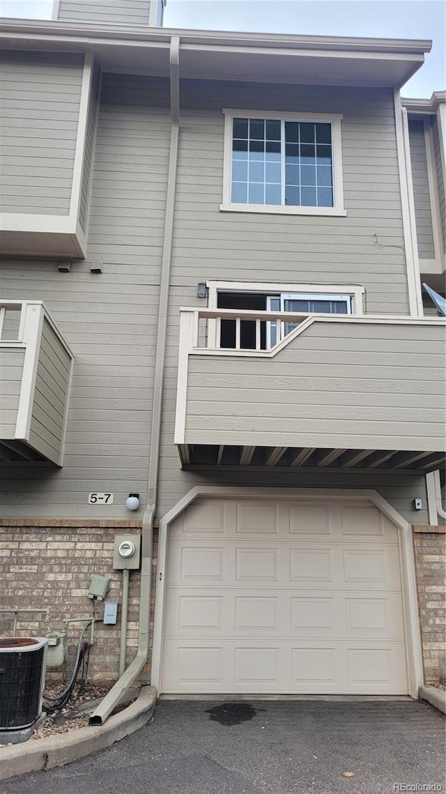 1818 S Quebec Way Unit 5-7, Denver, CO 80231 - rear view of property featuring cooling unit, an attached garage, and brick siding