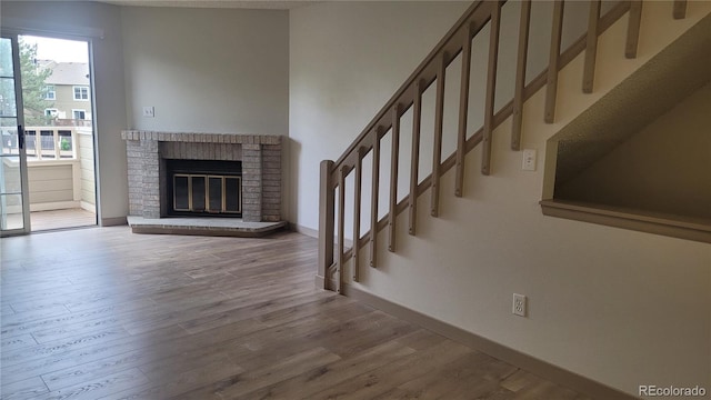 1818 S Quebec Way Unit 5-7, Denver, CO 80231 - unfurnished living room featuring wood finished floors, stairs, baseboards, and a fireplace