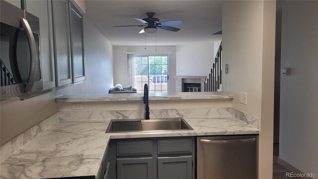 1818 S Quebec Way Unit 5-7, Denver, CO 80231 - kitchen featuring dishwasher, a sink, ceiling fan, gray cabinets, and a brick fireplace