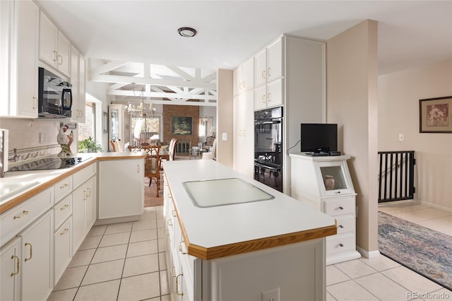 kitchen featuring a center island, white cabinetry, black appliances, and light tile patterned floors