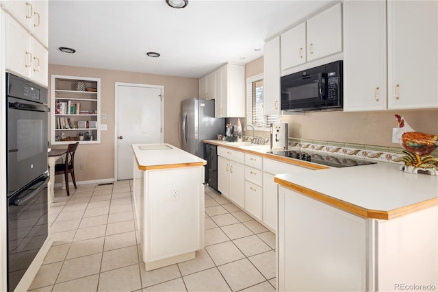 kitchen with a center island, light countertops, black appliances, a sink, and light tile patterned flooring