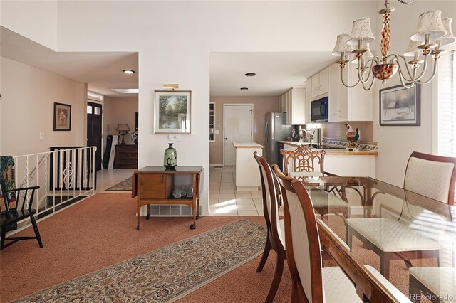 dining space with a chandelier, light tile patterned floors, and light colored carpet