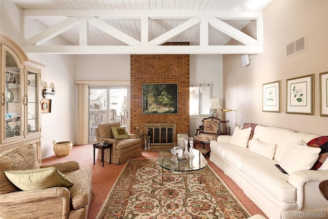 living area with visible vents, carpet, a brick fireplace, high vaulted ceiling, and beam ceiling