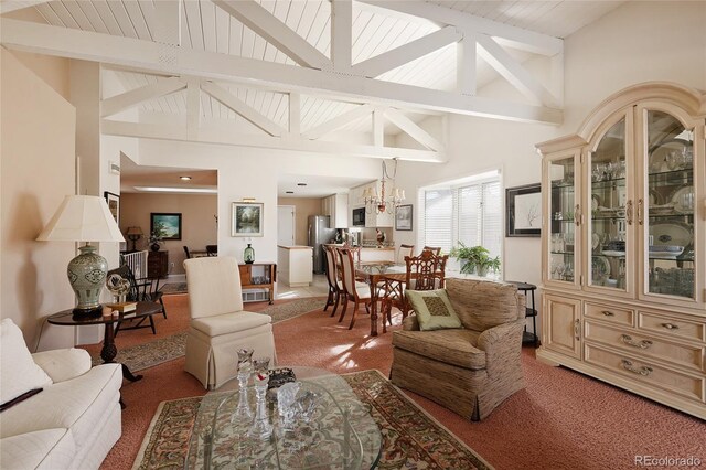 living room featuring high vaulted ceiling, light carpet, and beamed ceiling