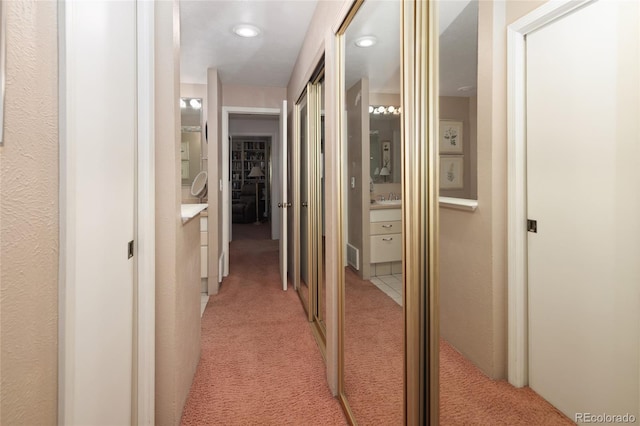 hallway featuring light carpet and recessed lighting