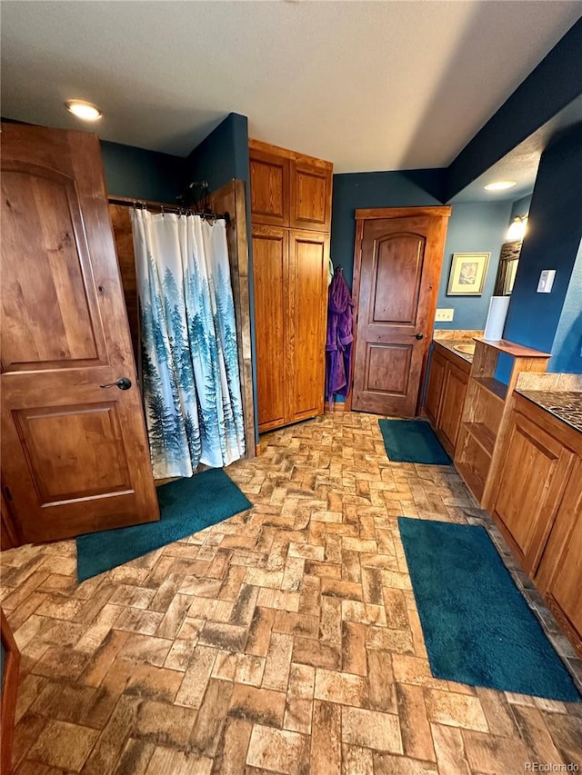 4618 SE Summit Trl, Evergreen, CO 80439 - full bathroom featuring curtained shower, brick flooring, and vanity