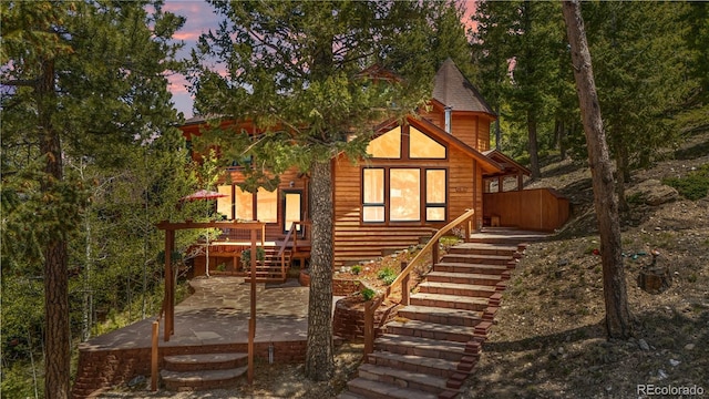4618 SE Summit Trl, Evergreen, CO 80439 - back of property at dusk with stairs and a patio area