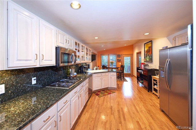 2141 S Dallas St, Denver, CO 80231 - kitchen featuring stainless steel appliances, vaulted ceiling, white cabinets, light wood-type flooring, and a peninsula