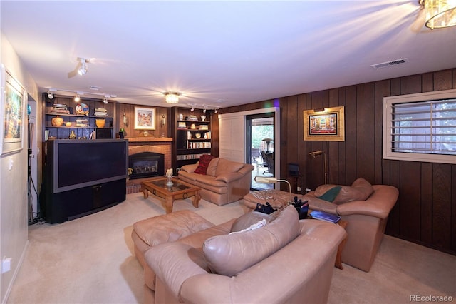 2141 S Dallas St, Denver, CO 80231 - living room featuring light colored carpet, wood walls, a brick fireplace, and built in features