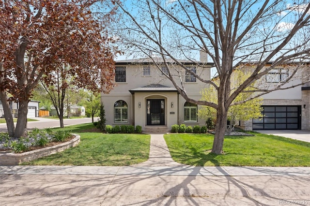 view of front of house with stucco siding, a chimney, a front yard, and a garage