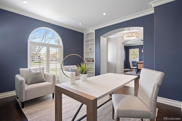dining area with arched walkways, baseboards, ornamental molding, recessed lighting, and wood finished floors