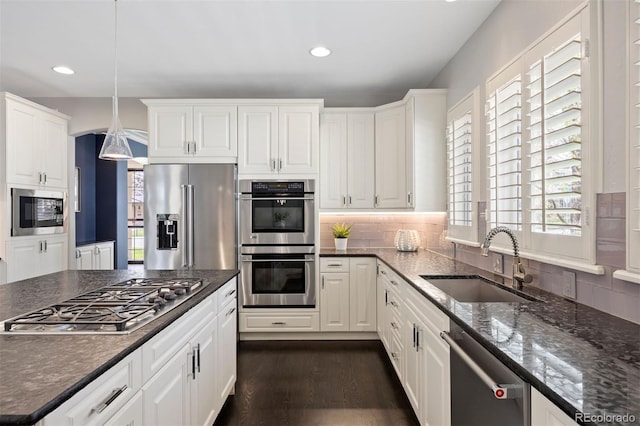 kitchen with appliances with stainless steel finishes, a sink, white cabinets, decorative backsplash, and recessed lighting