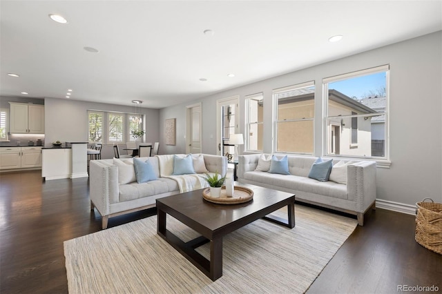 living area featuring recessed lighting, dark wood-style floors, and baseboards