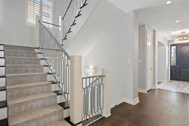 entryway with plenty of natural light, baseboards, wood finished floors, recessed lighting, and a chandelier