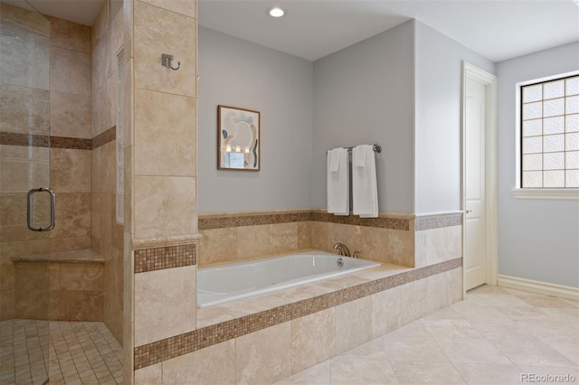bathroom with a shower stall, a garden tub, and recessed lighting