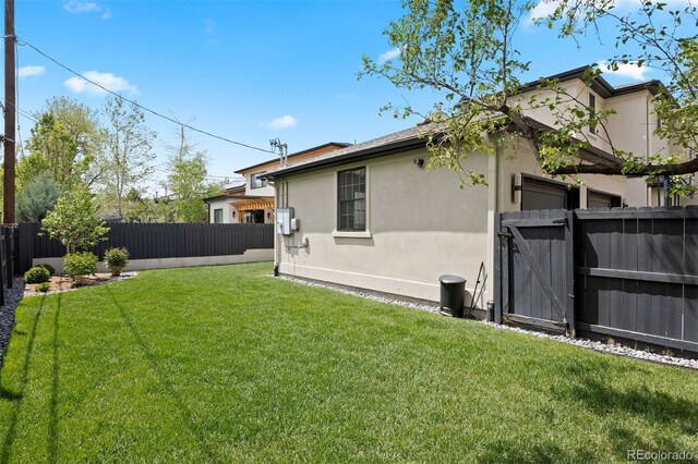 back of house with stucco siding and a gate