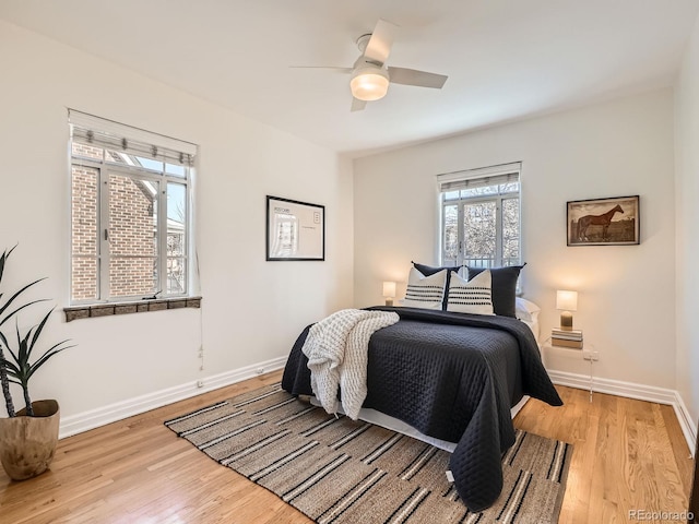 bedroom with ceiling fan, wood finished floors, and baseboards