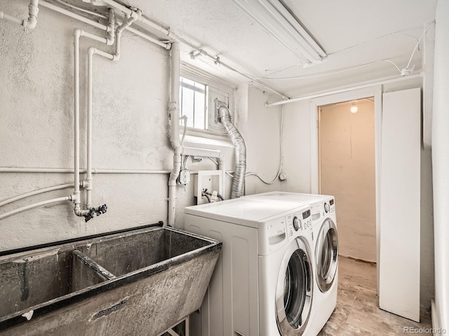 washroom with washer and dryer and a sink