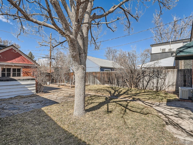 view of yard featuring central air condition unit and fence