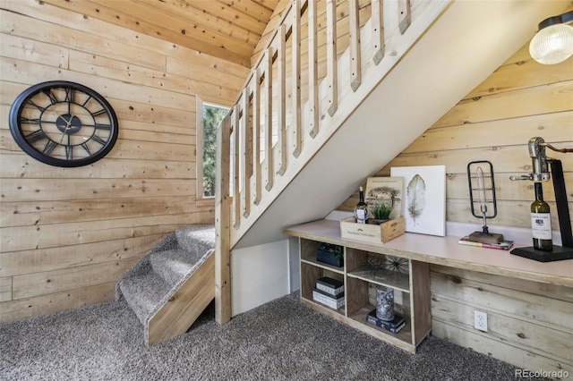 stairway featuring carpet floors, wooden walls, and wooden ceiling