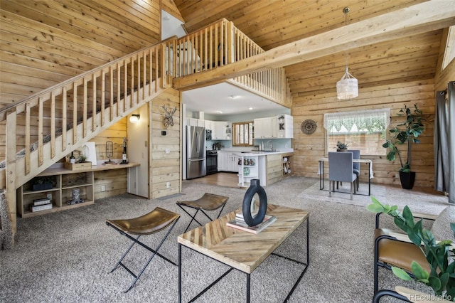 carpeted living room featuring a sink, stairway, a high ceiling, wood walls, and wood ceiling