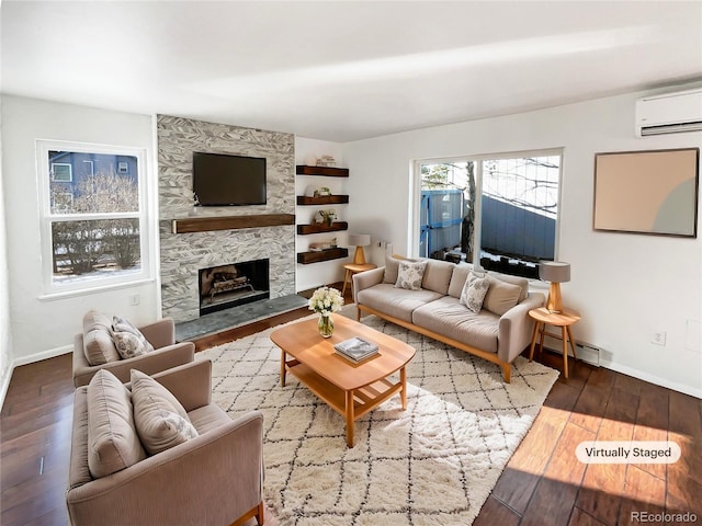 living room featuring a fireplace, hardwood / wood-style flooring, and a wall unit AC