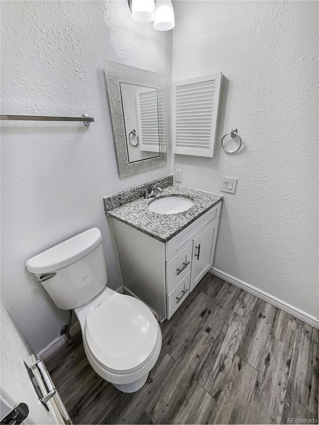 bathroom featuring vanity, toilet, and wood-type flooring