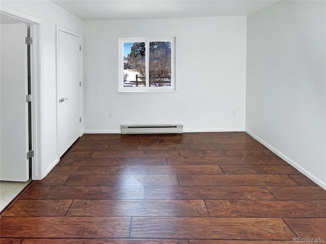 spare room with dark wood-type flooring and a baseboard radiator