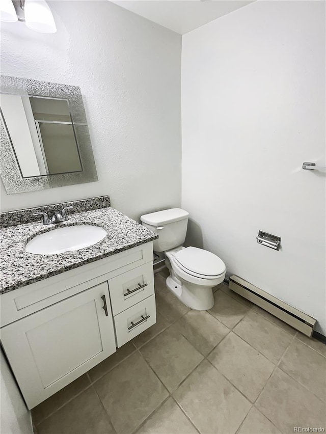 bathroom with tile patterned floors, vanity, a shower with door, a baseboard heating unit, and toilet