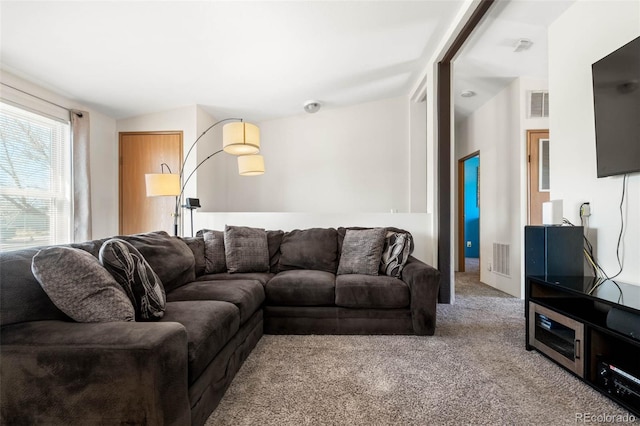 living area with visible vents and carpet