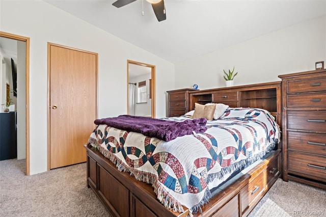 bedroom featuring light carpet, a ceiling fan, ensuite bath, and lofted ceiling