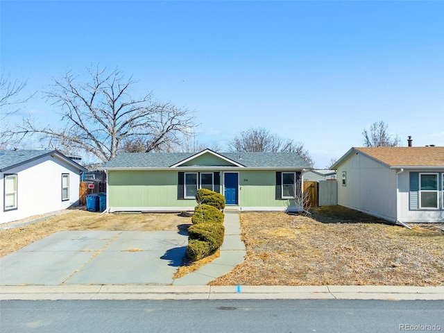 single story home with concrete driveway and fence