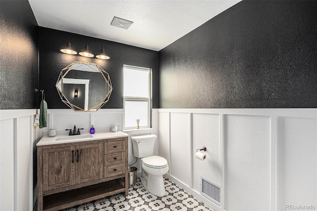 10731 E 151st Pl, Brighton, CO 80602 - bathroom with a wainscoted wall, toilet, a textured wall, and vanity