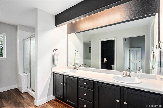 10731 E 151st Pl, Brighton, CO 80602 - full bath featuring a shower stall, wood finished floors, double vanity, baseboards, and toilet