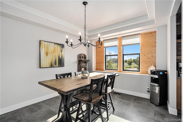 10731 E 151st Pl, Brighton, CO 80602 - dining space featuring a chandelier, baseboards, a tray ceiling, and dark tile patterned floors