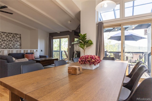 dining space with lofted ceiling with beams