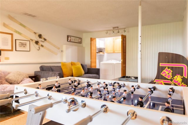 rec room featuring washer and clothes dryer, visible vents, and a textured ceiling