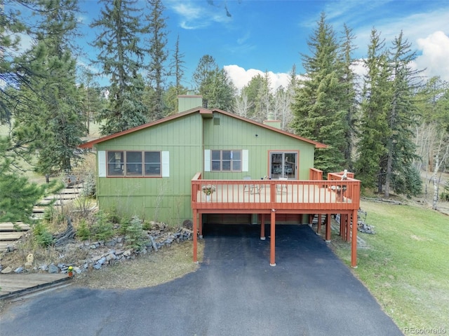 8473 Gray Fox Dr, Evergreen, CO 80439 - view of front of home with a carport, a wooden deck, a front yard, and aphalt driveway