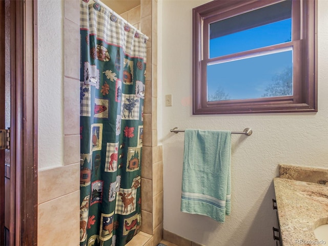 8473 Gray Fox Dr, Evergreen, CO 80439 - bathroom featuring vanity, a textured wall, and tiled shower