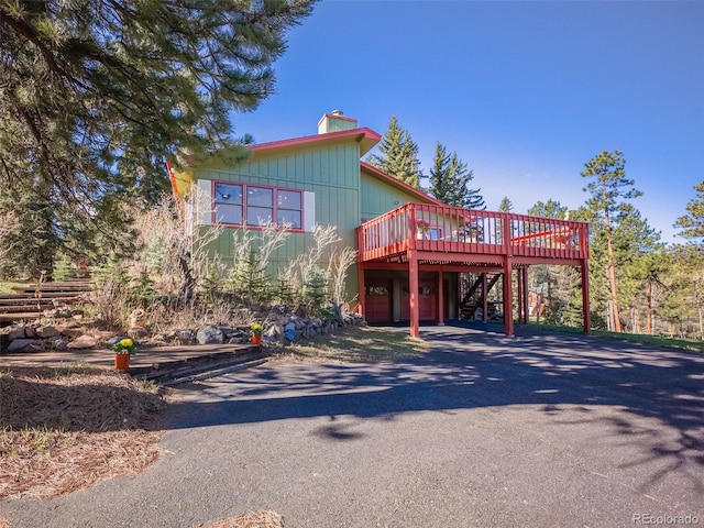 8473 Gray Fox Dr, Evergreen, CO 80439 - view of front facade with a deck, stairway, a chimney, a carport, and driveway