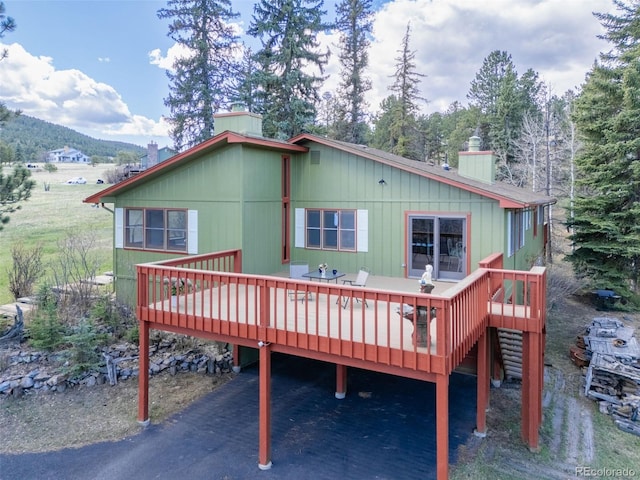 8473 Gray Fox Dr, Evergreen, CO 80439 - back of house featuring a deck with mountain view and a chimney