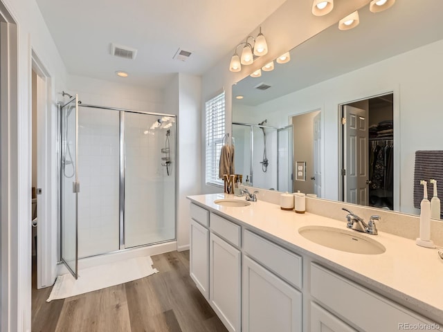 9054 Truckee Ct, Commerce City, CO 80022 - bathroom with a stall shower, a spacious closet, double vanity, wood finished floors, and recessed lighting